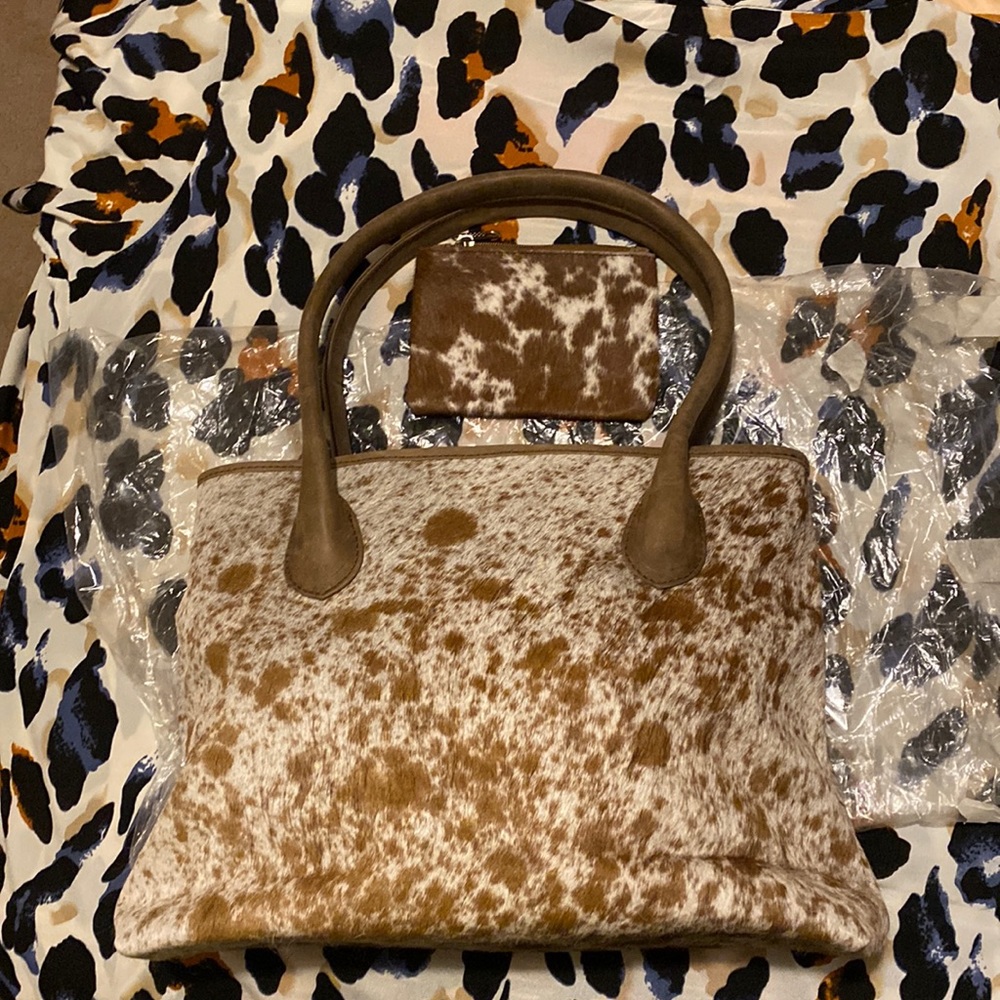 New, never used cow hide purse.  Red and cream color with coin purse.